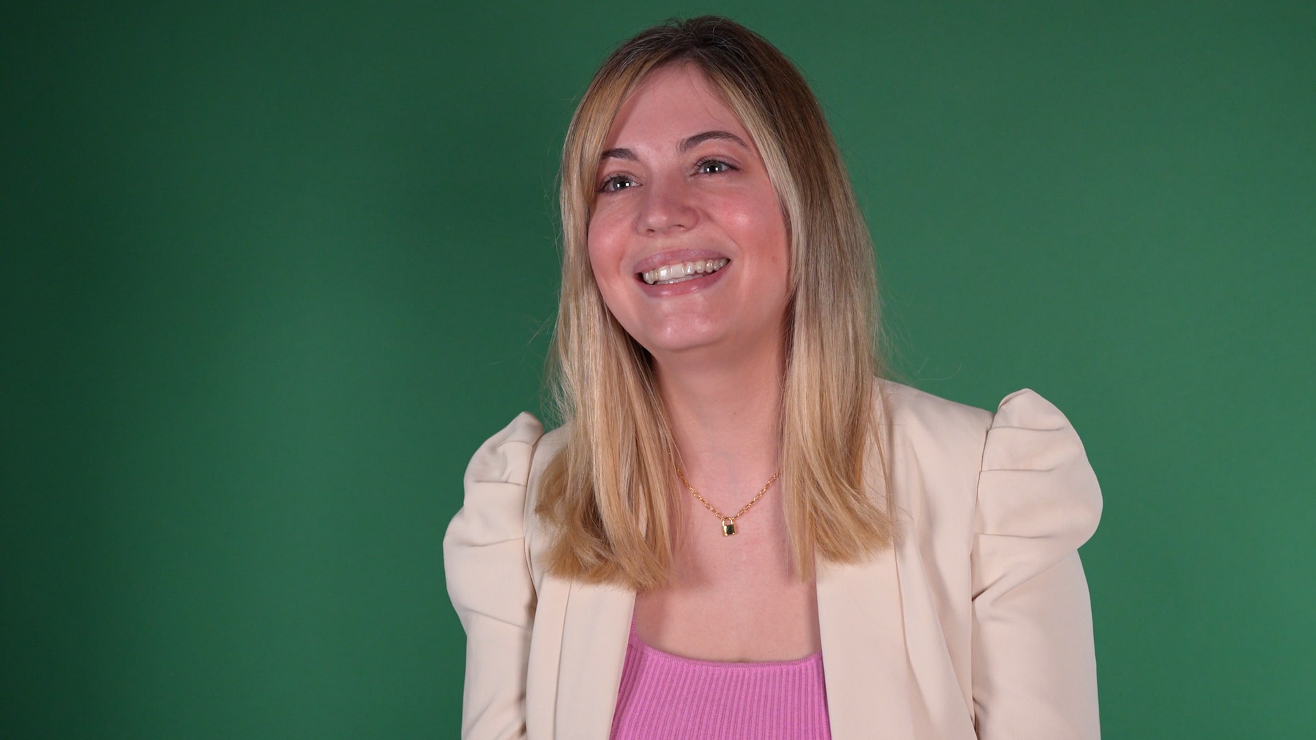 A woman smiling in front of a dark green background