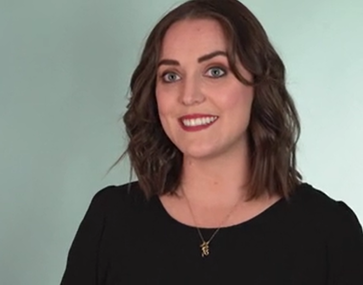 Autumn Theodore smiling in front of a light blue background